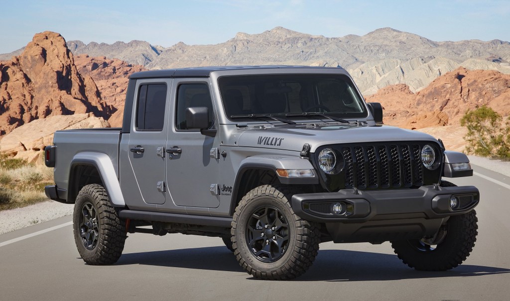 A Sting Gray 2021 Jeep Gladiator Willys in the middle of a road with a mountain backdrop