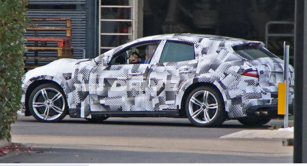 A Ferrari test mule for the Purosangue SUV is wrapped in spy camouflage. 
