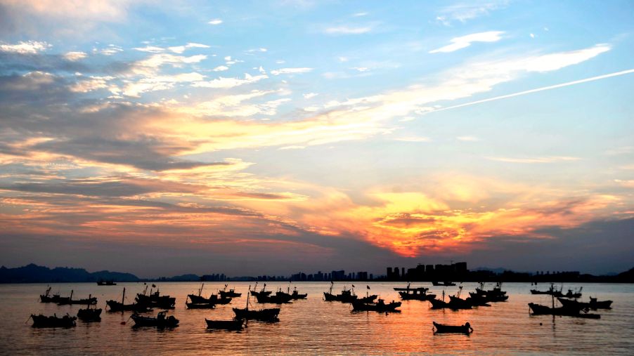 Returning fishing boats moor under the sunset in Qingdao, Shandong Province, China