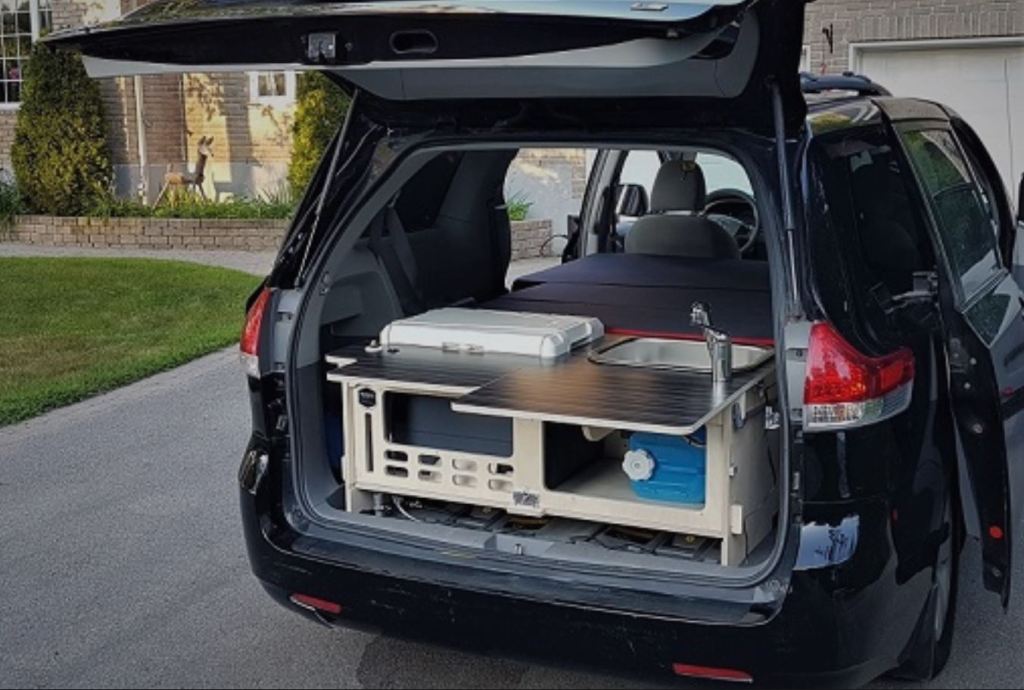 The back of a Toyota Sienna minivan has the Malibu 2 kit installed make a functional RV camper.