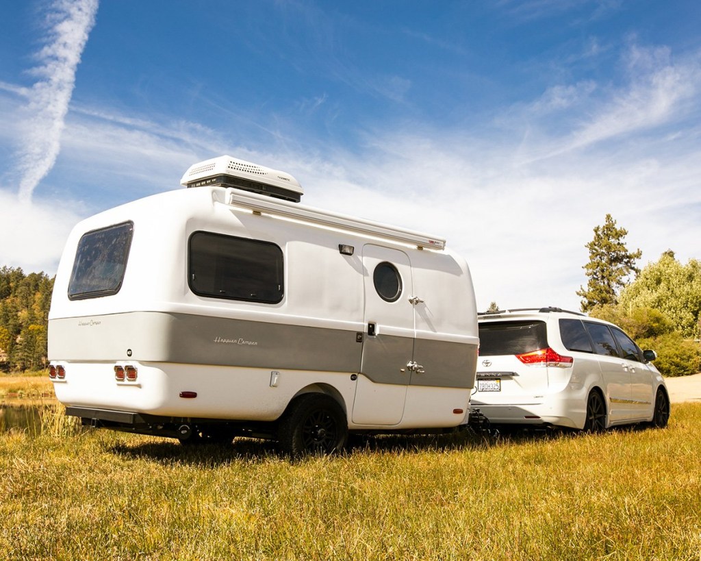 A white Toyota Sienna towing a white and gray HCT trailer.