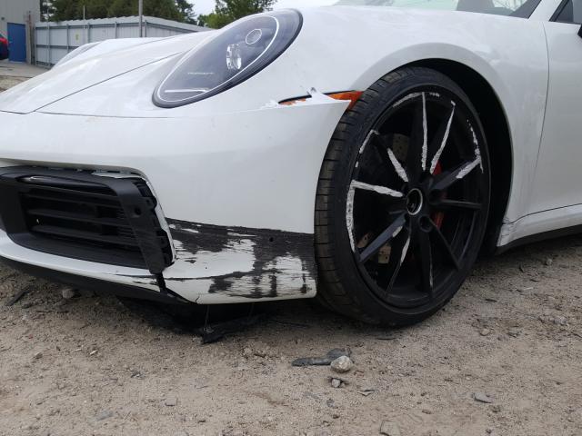 some damage on the front bumper and wheel of a white Porsche 