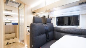 Interior view of a table, shower, and bed area in a HYMER camper van.