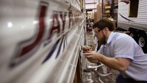 A worker at Jayco, Inc., the country's third largest maker of recreational vehicles, puts decals on a Jay Flight travel trailer