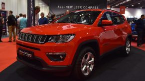 A red Jeep Compass on display at an auto show