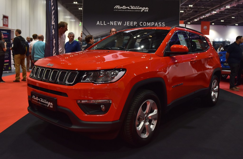 A red Jeep Compass on display at an auto show