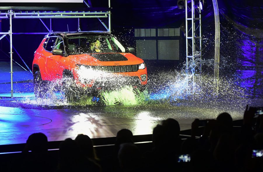 A red Jeep Compass puts its capability on display by driving into water