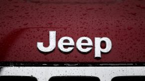 Jeep logo on red vehicle with rain drops over it