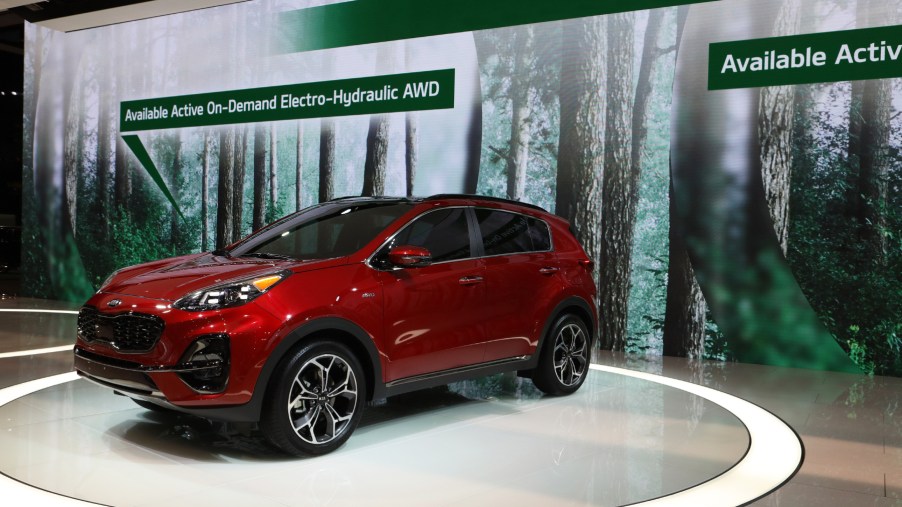 A Kia Sportage on display at an auto show advertising its available all-wheel-drive system