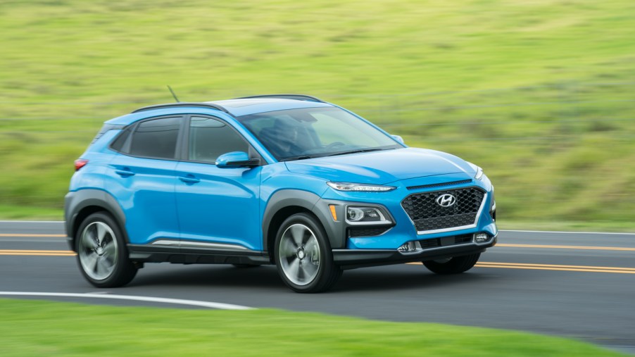 The 2021 Hyundai Kona driving around a curve of a road