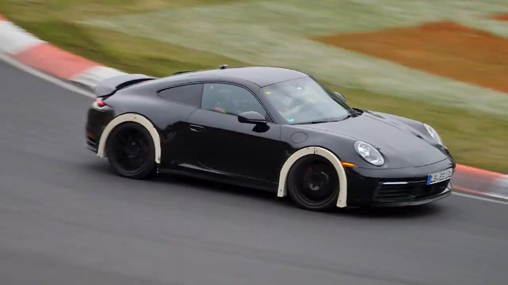 A black lifted Porsche 911 test mule on the Nurburgring