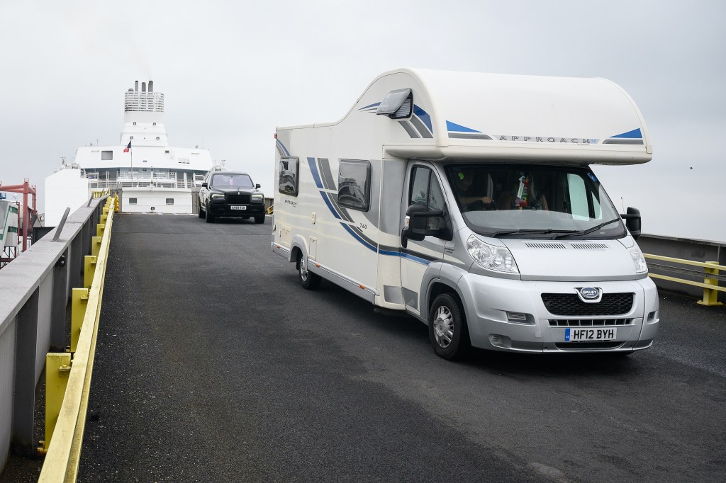 A motorhome RV drives down the exit ramp as travelers from France disembark from a Brittany Ferries ship