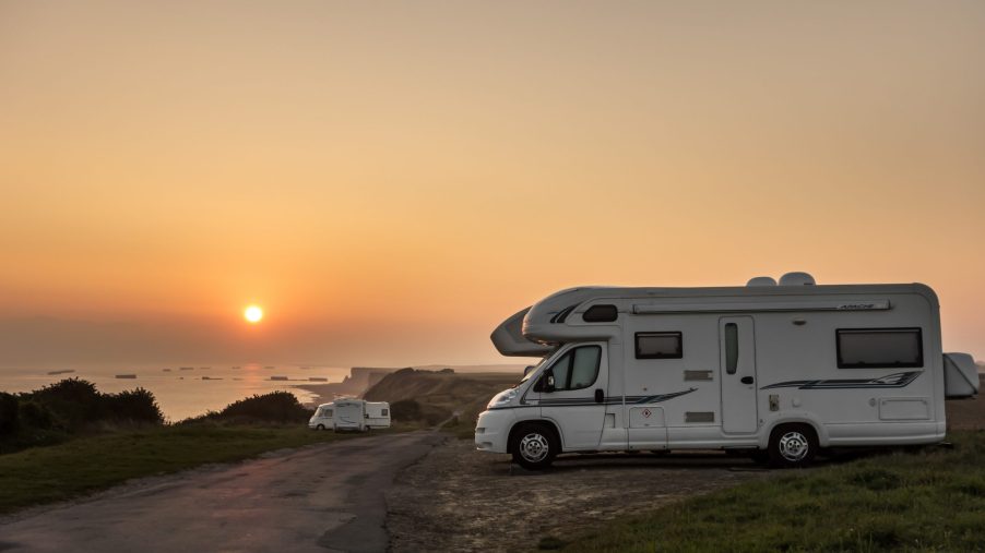 Motorhomes parked along the coast at sunset with view over the sea
