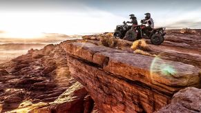 Two riders take the Polaris Scrambler XP 1000 S to a scenic overlook.