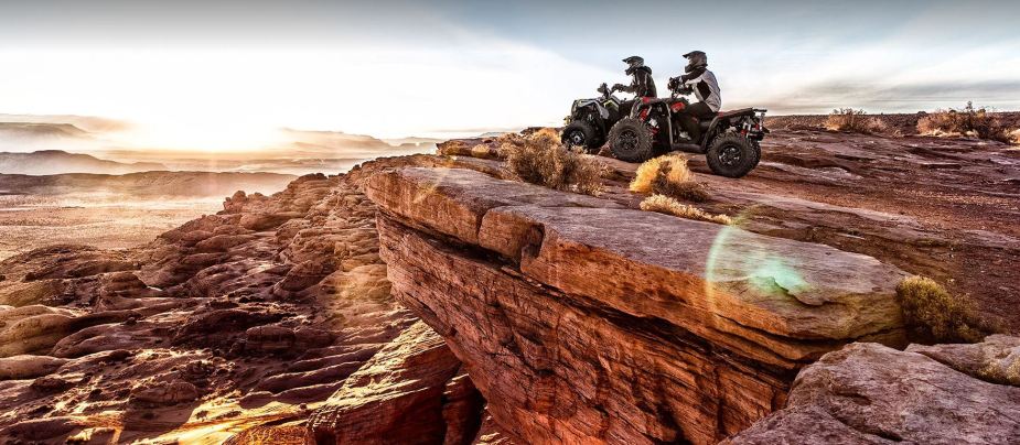 Two riders take the Polaris Scrambler XP 1000 S to a scenic overlook.