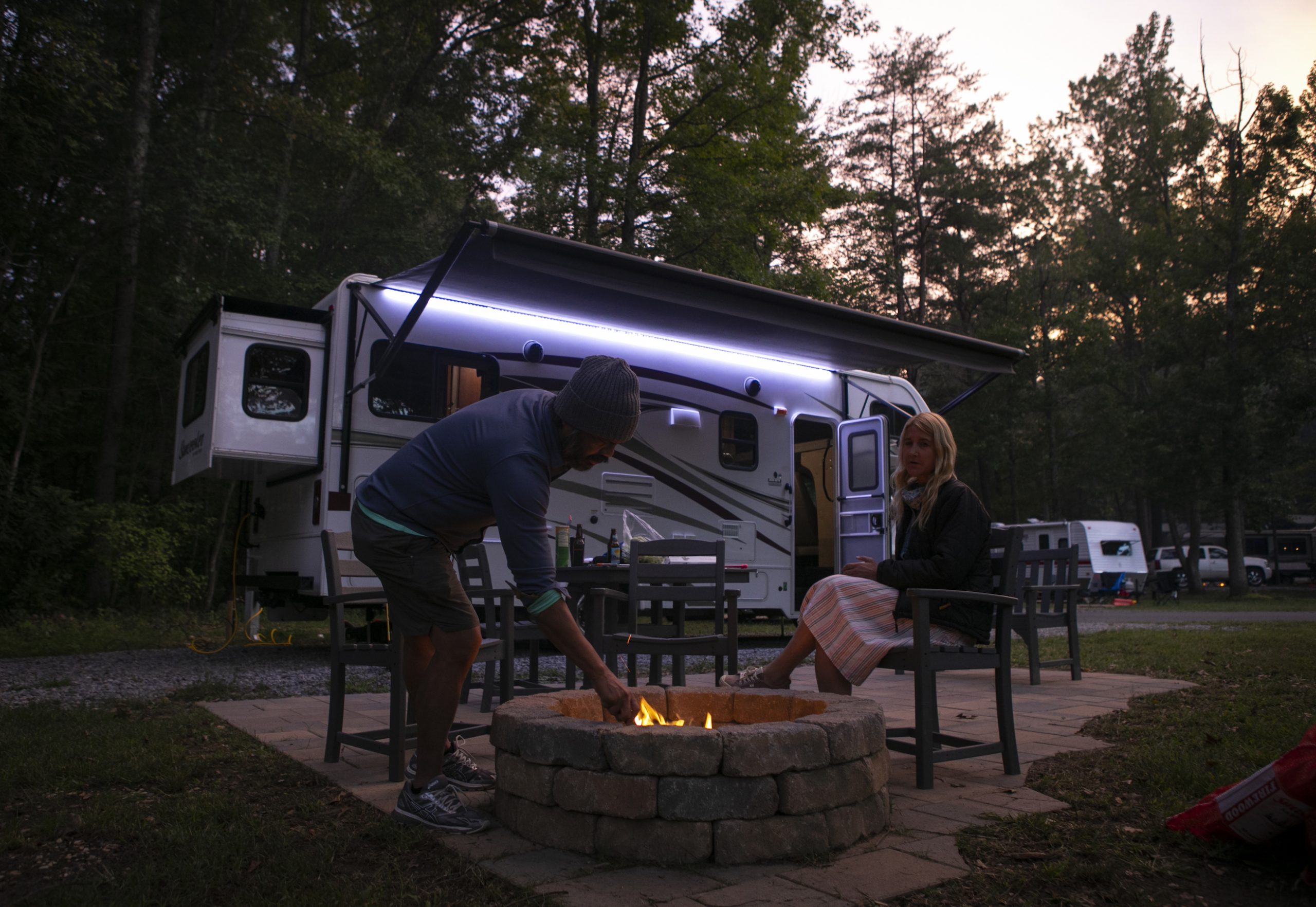 Christian Arriola and Washington Post travel writer Andrea Sachs sit around a fire outside of their rented RV