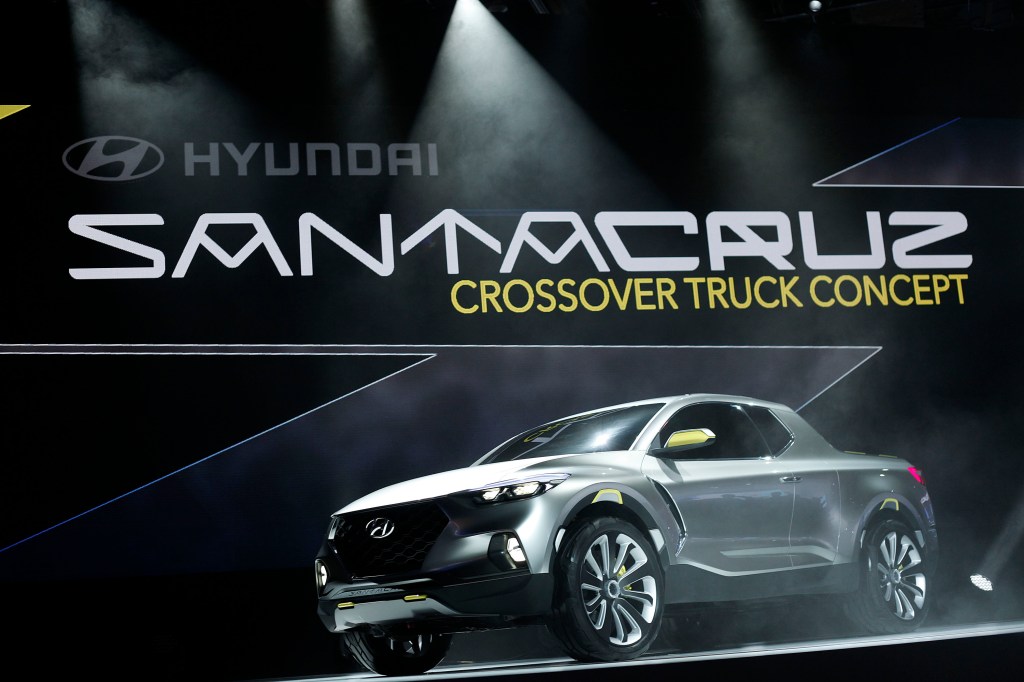 A silver extended cab pickup sits on stage. It is the Santa Cruz concept from Hyundai.