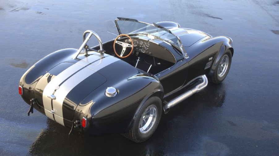 The overhead rear 3/4 view of a gray-and-white Shelby Cobra 427 S/C CSX-Series 6000 continuation on a blacktop