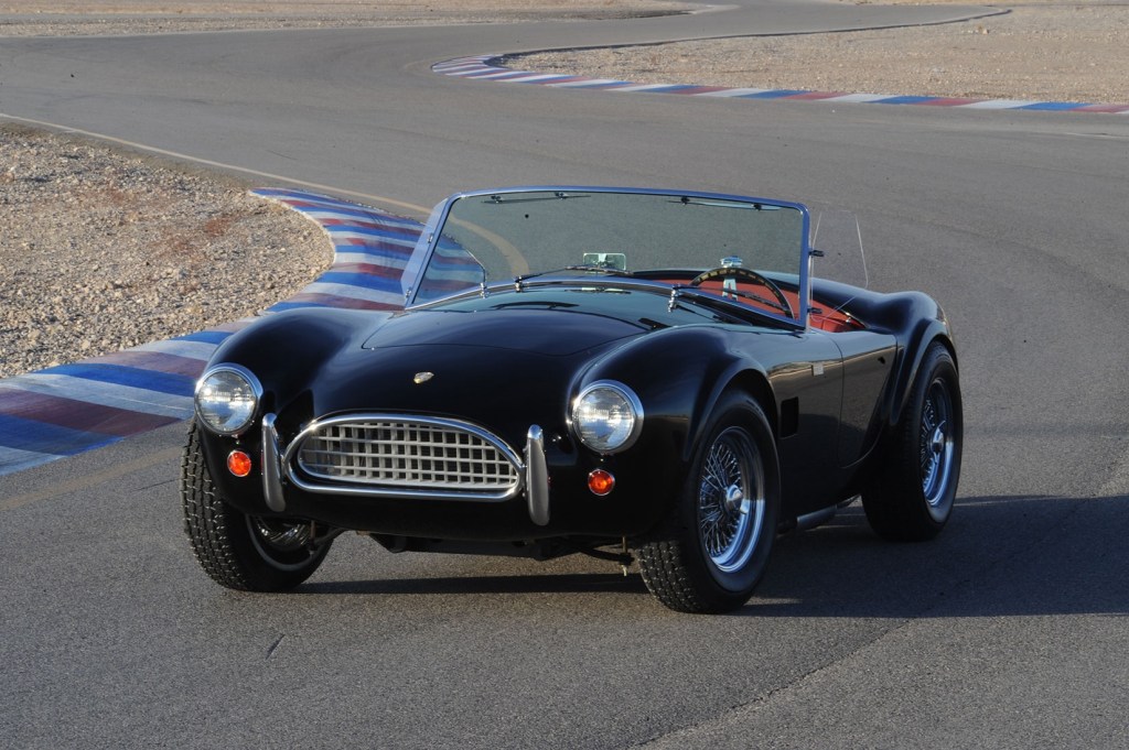 A black Shelby Street Cobra 289 on a racetrack