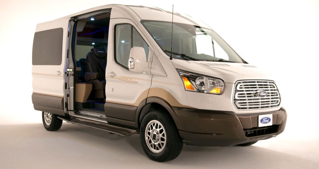 A white, full-size, conversion van based on a Ford Transit.