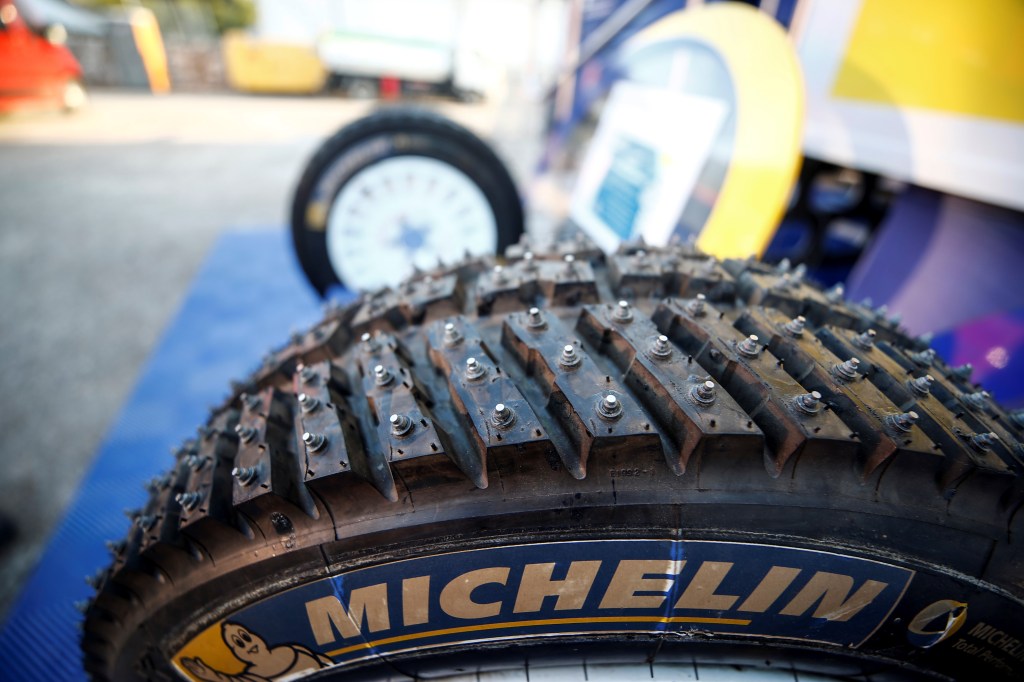 A studded snow tire from Michelin is waiting to be used on a rally car during the next maintenance stop.