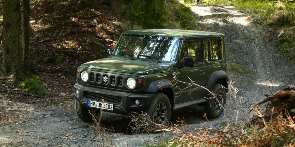 The Suzuki Jimny off-roading thoruhg a stream in the woods