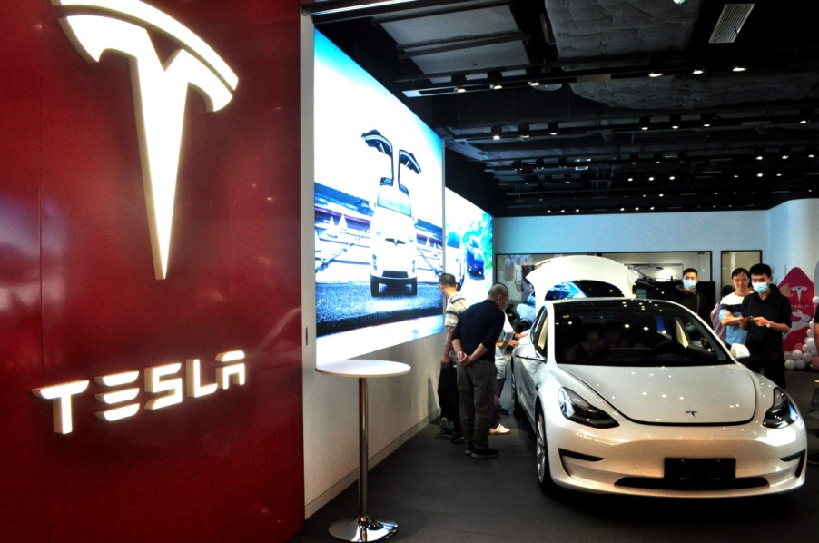 People checking out a Tesla on display at a dealership