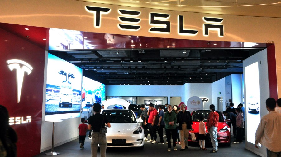 People look at electric vehicles at a Tesla store