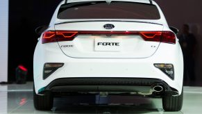 The back of a white Kia Forte on display at an auto show
