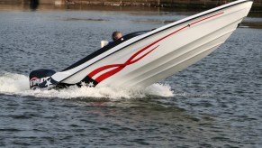 speed boat with its nose out of the water, exposing the bottom of the boat above the water
