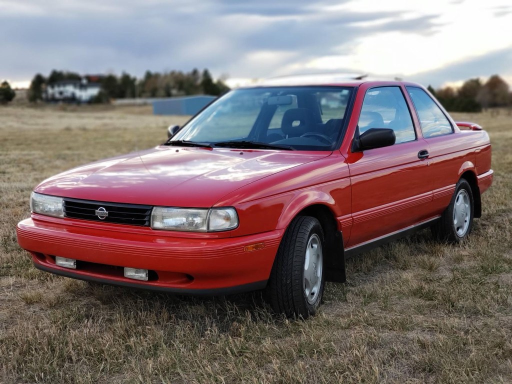 A red 1991 Nissan Sentra SE-R in a field