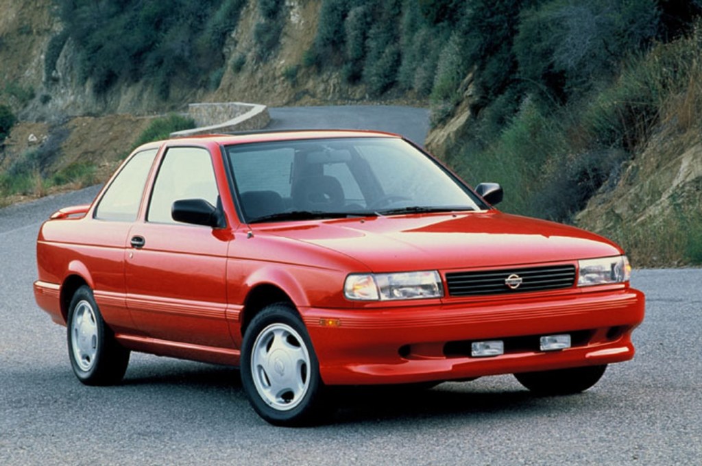 A red 1994 Nissan Sentra SE-R parked on a mountain road