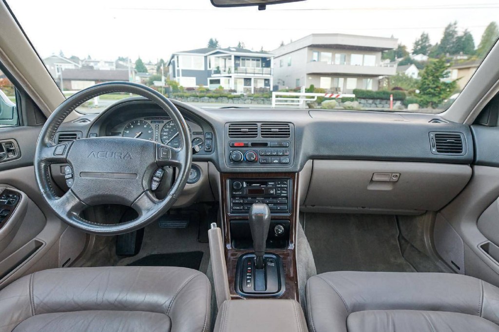 The brown-leather front seats and brown-black dashboard of a 1995 Acura Legend L
