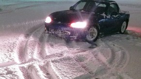 A blue 1999 Mazda MX-5 Miata parked on the snow