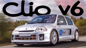 A silver 2002 Renault Sport Clio V6 drives down the road