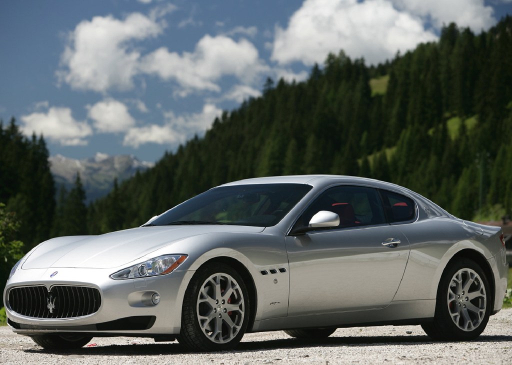 A silver 2008 Maserati GranTurismo in front of a forested mountain