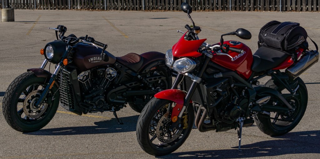 A red 2012 Triumph Street Triple R in front of a maroon 2021 Indian Scout Bobber