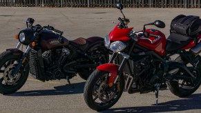 A red 2012 Triumph Street Triple R in front of a maroon 2021 Indian Scout Bobber