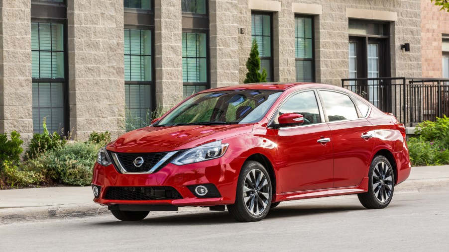 A red 2019 Nissan Sentra driving down a city street