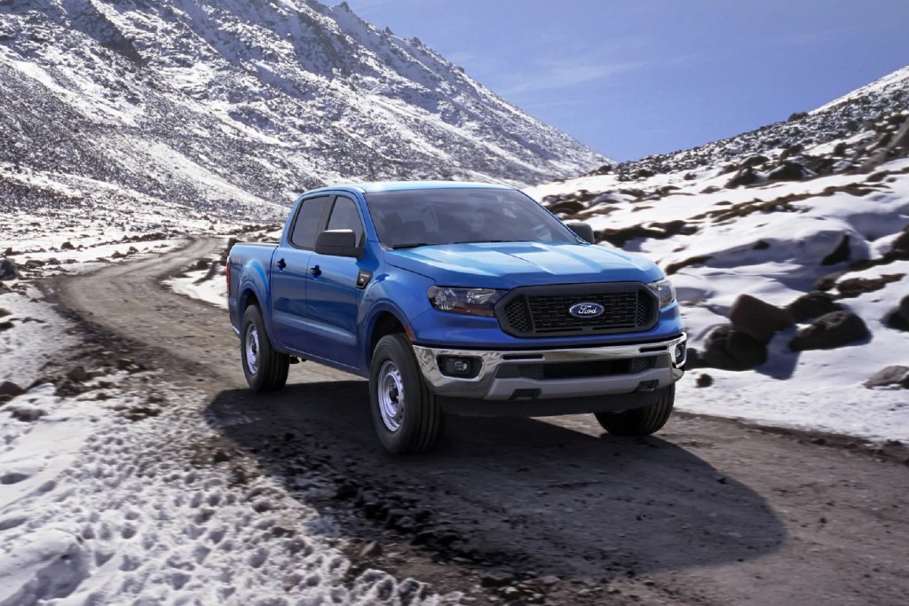A blue 2020 Ford Ranger XL SuperCrew drives on a paved snowy mountain road