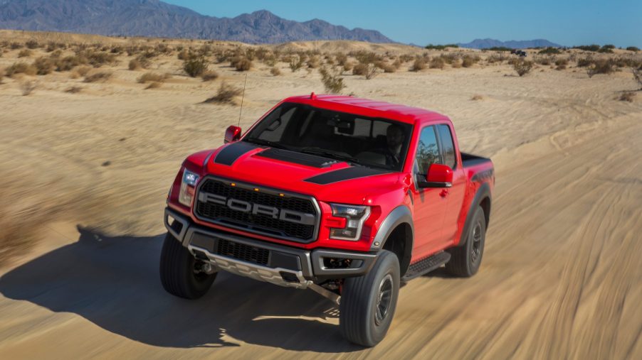 A red 2020 Ford Raptor runs through the desert.