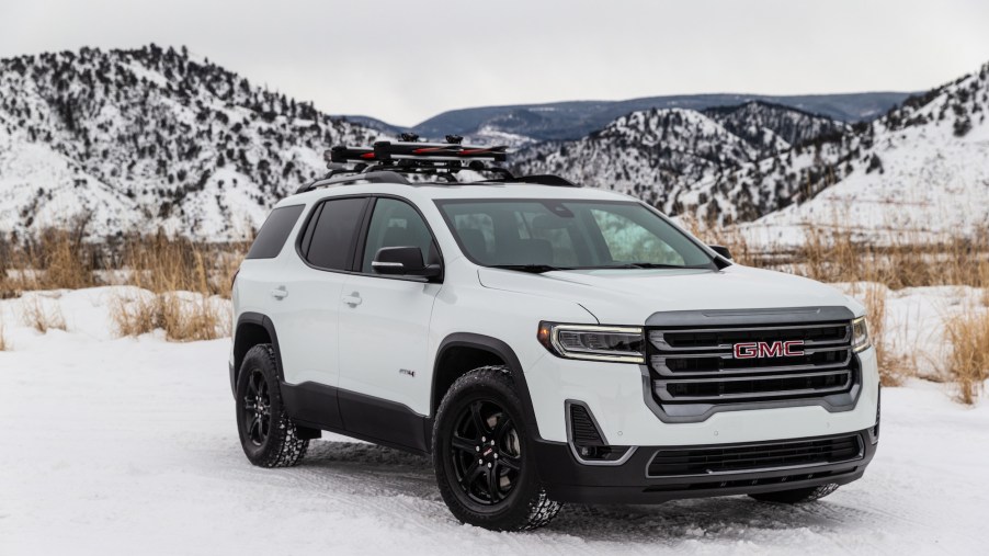 A white 2020 GMC Acadia AT4 is parked in the snow.