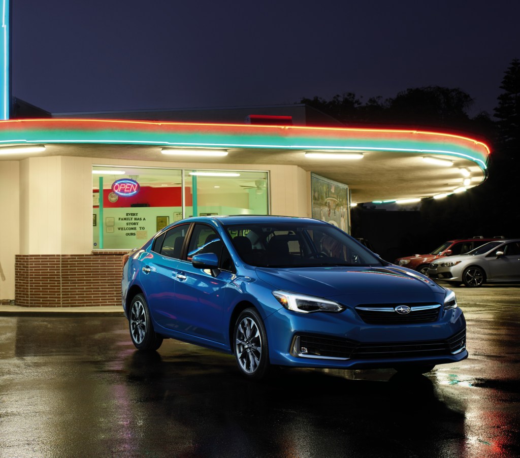 A blue 2020 Subaru Impreza on display in front of a retro diner.