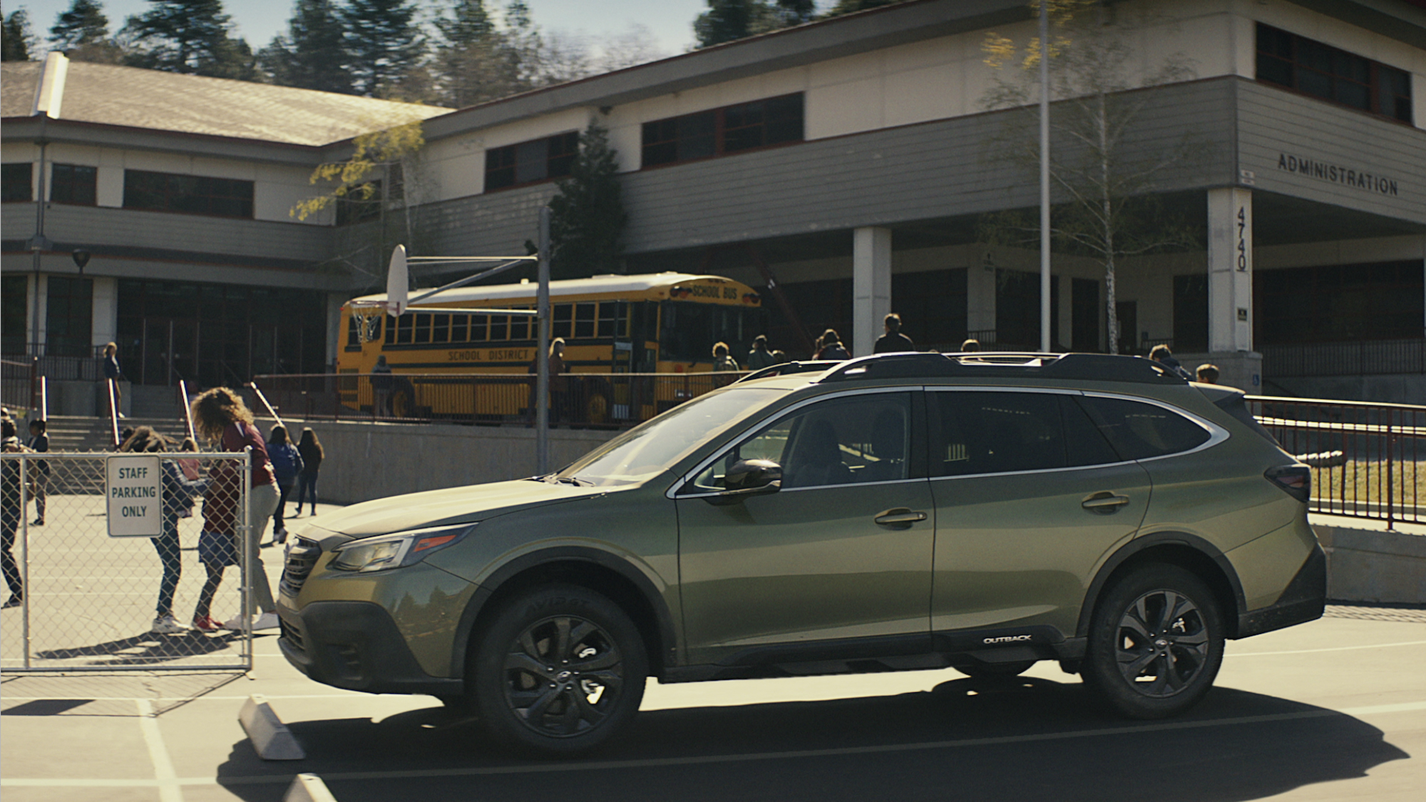 A 2020 Subaru Outback parked in front of a school.
