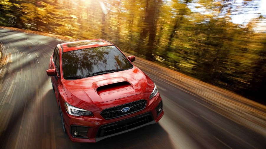 A red 2020 Subaru WRX Limited drives through a forest