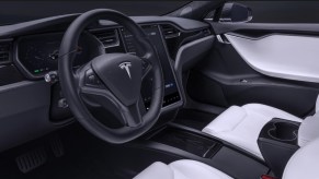 The 2020 Tesla Model S' white front seats, black dashboard, and central screen