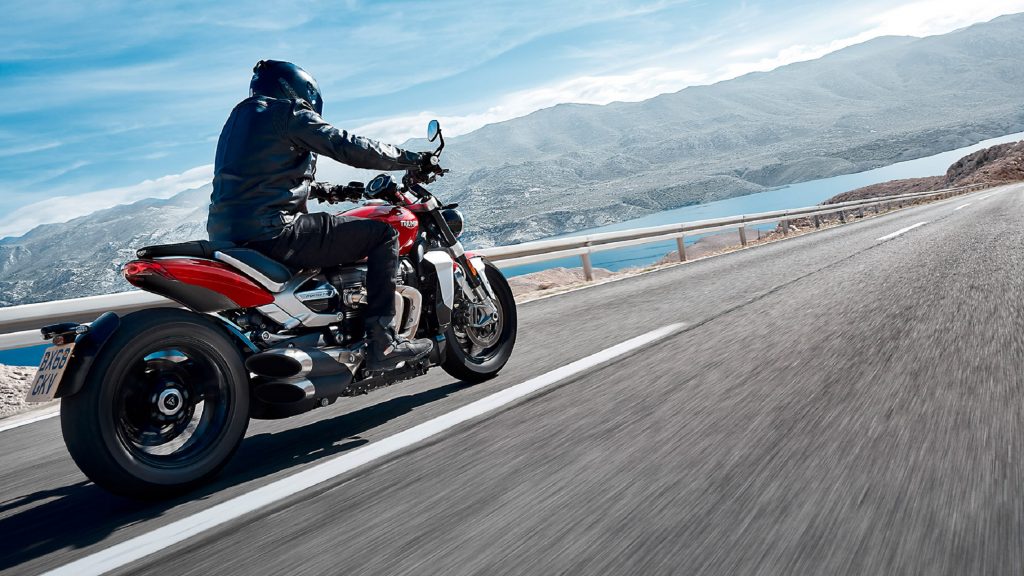The rear 3/4 view of a red 2020 Triumph Rocket 3 on the road