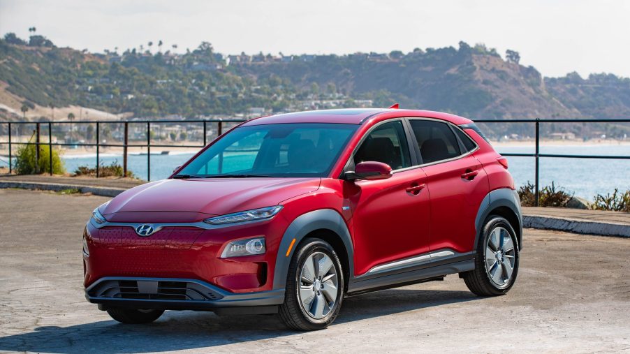 red 2020 Kona Electric subcompact SUV parked near the coast