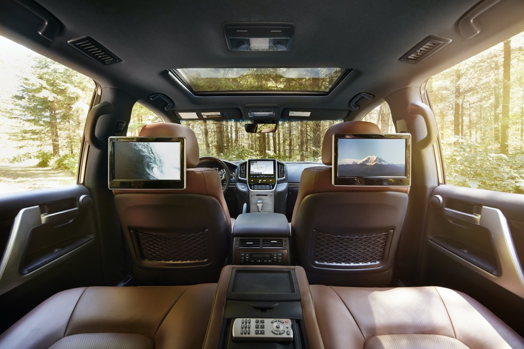 the interior of the 2021 Toyota Land Cruiser with brown leather, a sun roof, and rear entertainment screens.