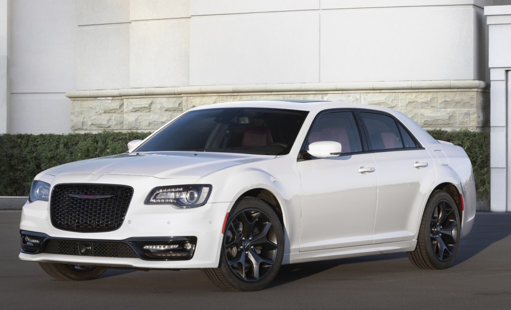A white 2021 Chrysler 300S parked on display in front of a building